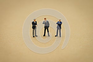 Miniature 3 people businessmen standing with back Negotiating in business. as background business concept and strategy concept