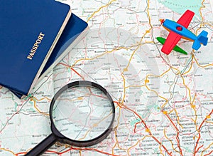 Miniature airplane, passport and magnifying glass on map , travel around the world