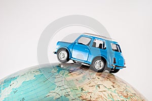 NIS, SERBIA - JANUARY 8 2018 Miniature figure toy car Mini Morris on geographical globe of earth on white background in studio