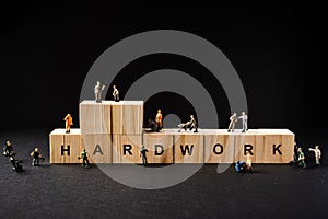 Miniature Builder Figures around Wooden Blocks with â€œHARDWORKâ€ wordings