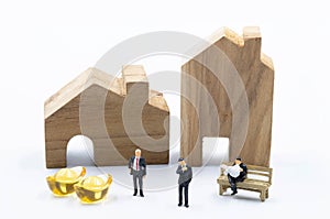 The miniature business man with the Gold in front of the building Land isolate on white background Investiment  Concept photo