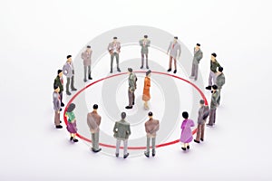 Miniature business people standing in circle over backdrop or ba