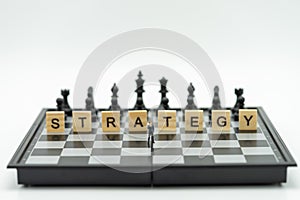 Miniature businessmen standing on a chessboard with a chess piece on the back. as background business concept with copy space