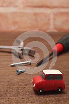 Miniature car and maintenance tools on wood.