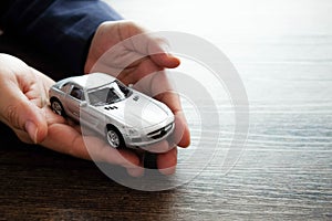 Miniature car model on hand, Auto dealership and rental concept