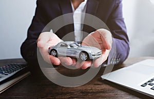 Miniature car model on hand, Auto dealership and rental concept