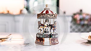 Miniature Carousel Toy over white marble top table with blur background