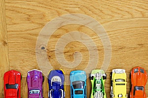 Miniature cars lined up on a wooden floor