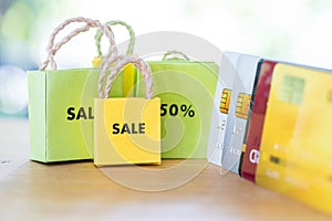 Miniature colorful paper bags and a word sale in front