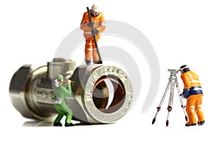 Miniature construction workers plumbing valve