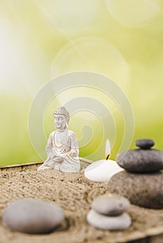Miniature desk zen sandbox with Buddha figure sit in Lotus position, stacked zen sea stones.