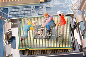 Miniature engineers or technician workers repairing CPU on the motherboard. Computer service and technology concept.