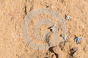 Miniature famer figure on sand hill field