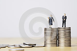 Miniature figure of businessman standing on equal coins stacking of  businesswoman for equality of gender male and female of
