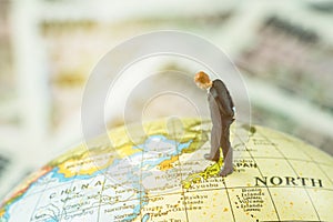 Miniature figure country leader man standing and looking at north korea map on globe as world critical nuclear missile war