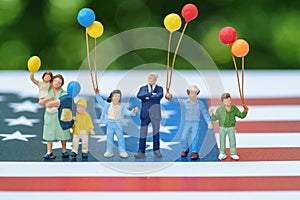 Miniature figure, happy american family holding balloon with Uni