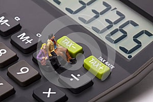 Miniature figure people on a calculator