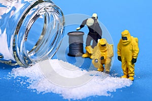Miniature figure people inspecting a salt spillage