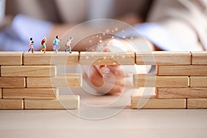 Miniature figure running on wood block crossing bridge