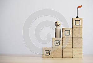 Miniature figure smile and standing on second step with winner flag on the top of step for progress and achieve project business