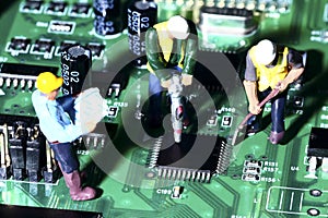 Miniature figure workmen on an electronic circuit board