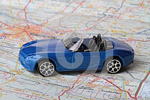 Miniature figurine of a car on a roadmap