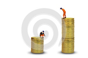 Construction worker standing on top of stacked golden coins isolated on white background.