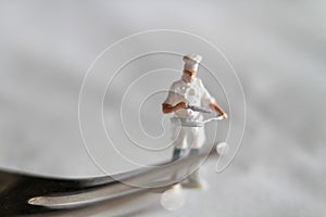 miniature figurine of a chef with a fork preparing some food