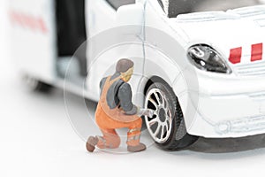 miniature figurine of a mechanic changing the wheel of a van