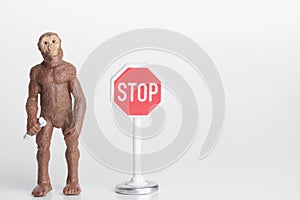 Miniature figurine of a prehistoric hominid with a stop sign photo