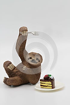 miniature figurine toy of a sloth with a slice of cake