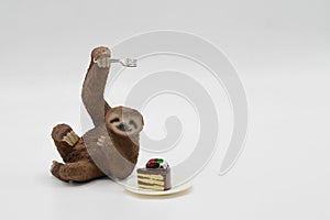 miniature figurine toy of a sloth with a slice of cake