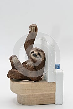 miniature figurine toy of a sloth on toilet - constipation concept