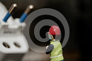 miniature figurine of a worker with electric plug