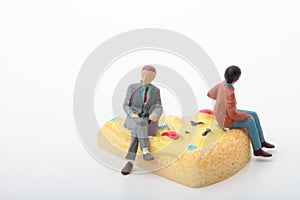 Miniature figurines of people sitting on a giant slice of pizza