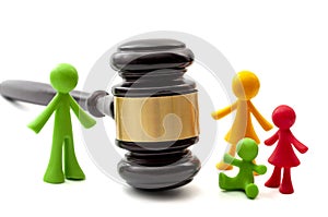 Miniature figurines representing father, mother and children separated by judge gavel concept for family law ruling, joint