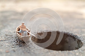 Miniature fishermen are fishing by boat