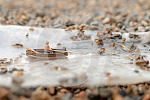 Miniature fishermen are fishing by boat