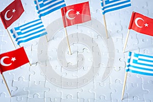 miniature flags of greece and turkey sticking out of white puzzle pieces, The concept of mutual relations between the two