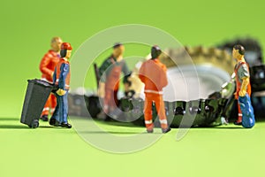 Miniature garbage man sorting beer caps for recycling and reuse to clean the enviroment from trash