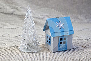 Miniature glas christmas tree and winter house made of paper  handmade  close-up on a light background