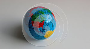 Miniature globe on a white surface with conventionally drawn continents