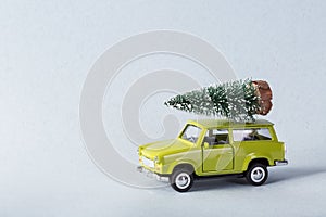 Miniature green car with x-mas tree on is top
