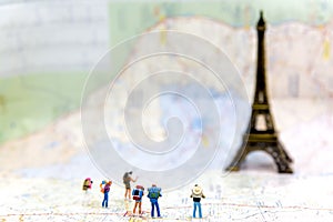 Miniature Group hiker and traveler backpack standing on wold map for travel Eiffel Tower in France and around the world,