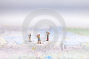 Miniature Group traveler with backpack standing on wold map for travel around the world. Travel Concept, photo