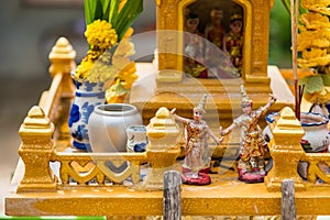 Miniature guardian spirit house. Small buddhist temple shrine, colorful flower garlands. San phra phum erected to bring fortune.