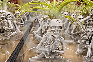 Miniature halloween themed skeleton figurines are doing different yoga movements.