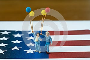 Miniature happy american family holding balloons standing on Uni