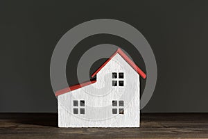 Miniature house on black background. Home construction concept. Front view