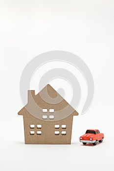 Miniature house and car on white background.